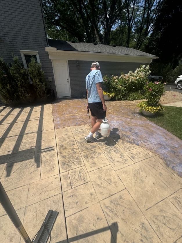 Super Shine Services technician applying seal coating to a stamped concrete patio